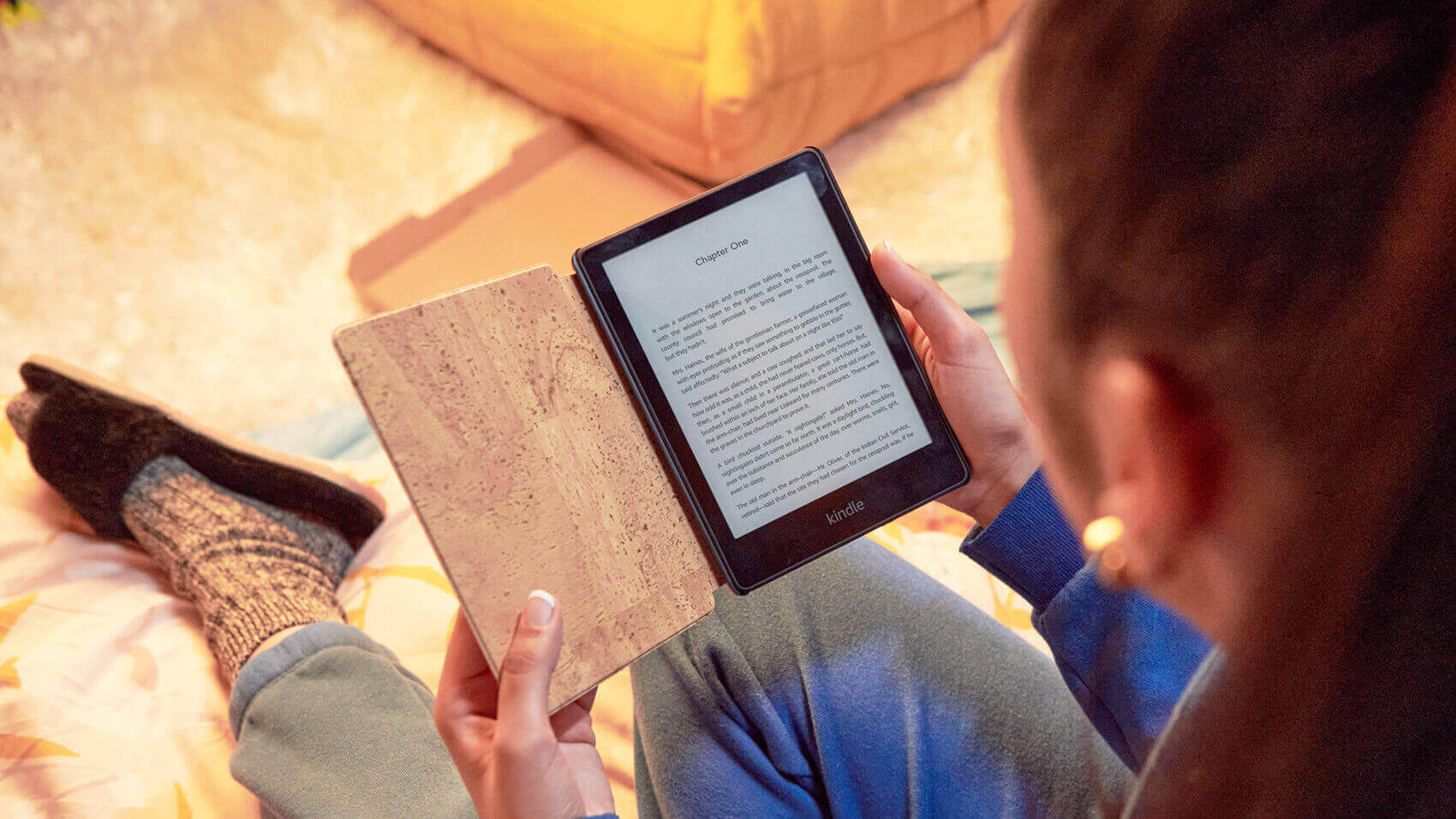 A person reading a Kindle e-reader displaying a page of text