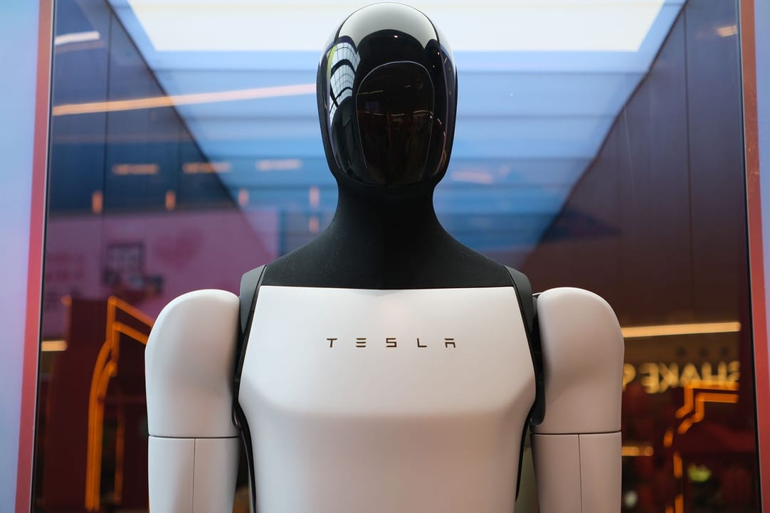 A white humanoid robot with a Tesla logo on its chest