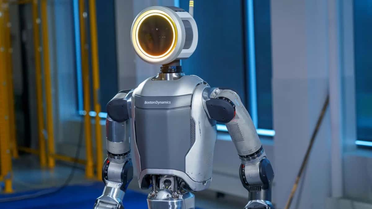 A Boston Dynamics Atlas humanoid robot, its round head lit with a glowing amber ring